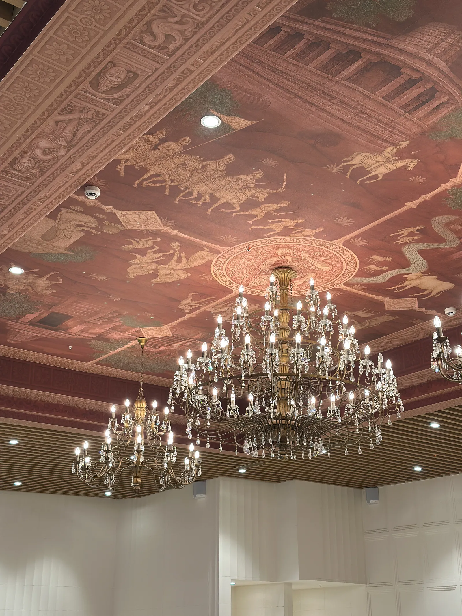 Banquet hall ceiling with painted mural and crystal chandelier — Chalukya Samrat
